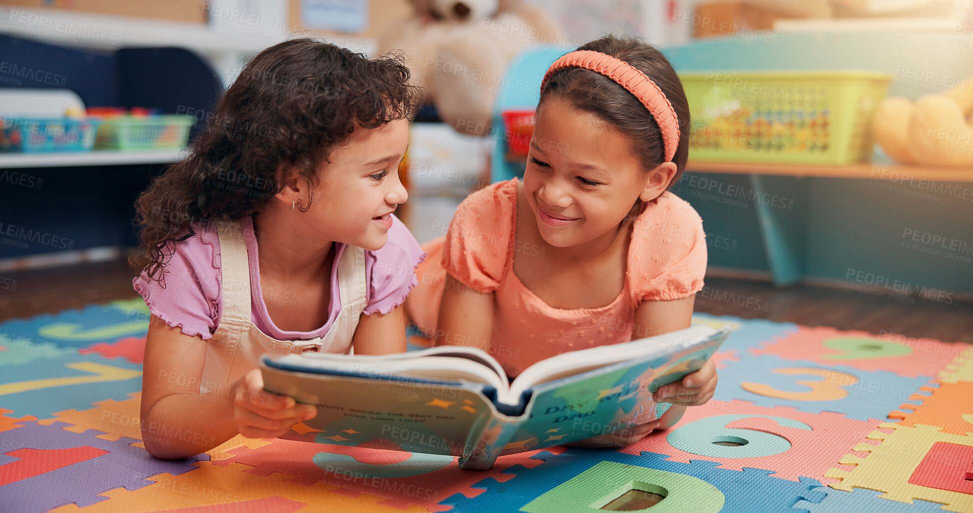 Buy stock photo Girls, reading book and friends on carpet, school and learning with education, smile and bonding together. Relax, storytelling and kids in classroom, literacy knowledge and happiness with discussion