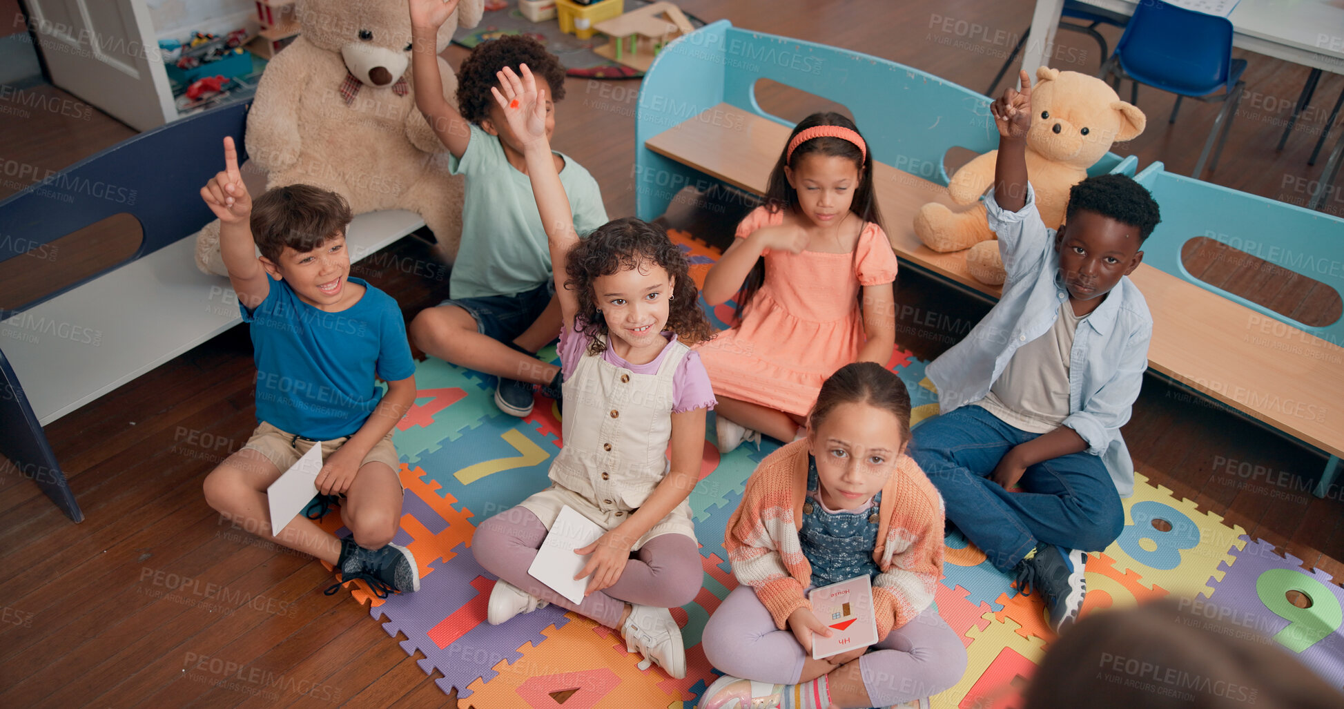 Buy stock photo Lesson, children or hands raised with question in classroom for creative development, feedback or knowledge. Above, flashcard and students on floor for memory learning or study progress at montessori