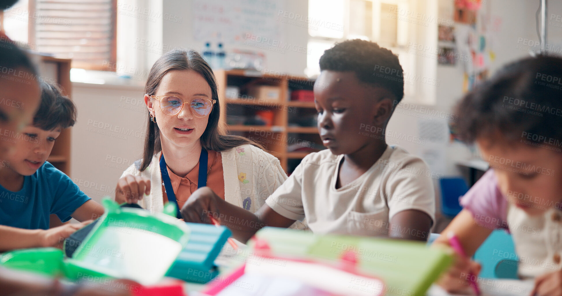 Buy stock photo Writing, education and educator helping children in classroom for language development, learning or growth. Notebook, advice and woman teacher with kid students for lesson at elementary school.