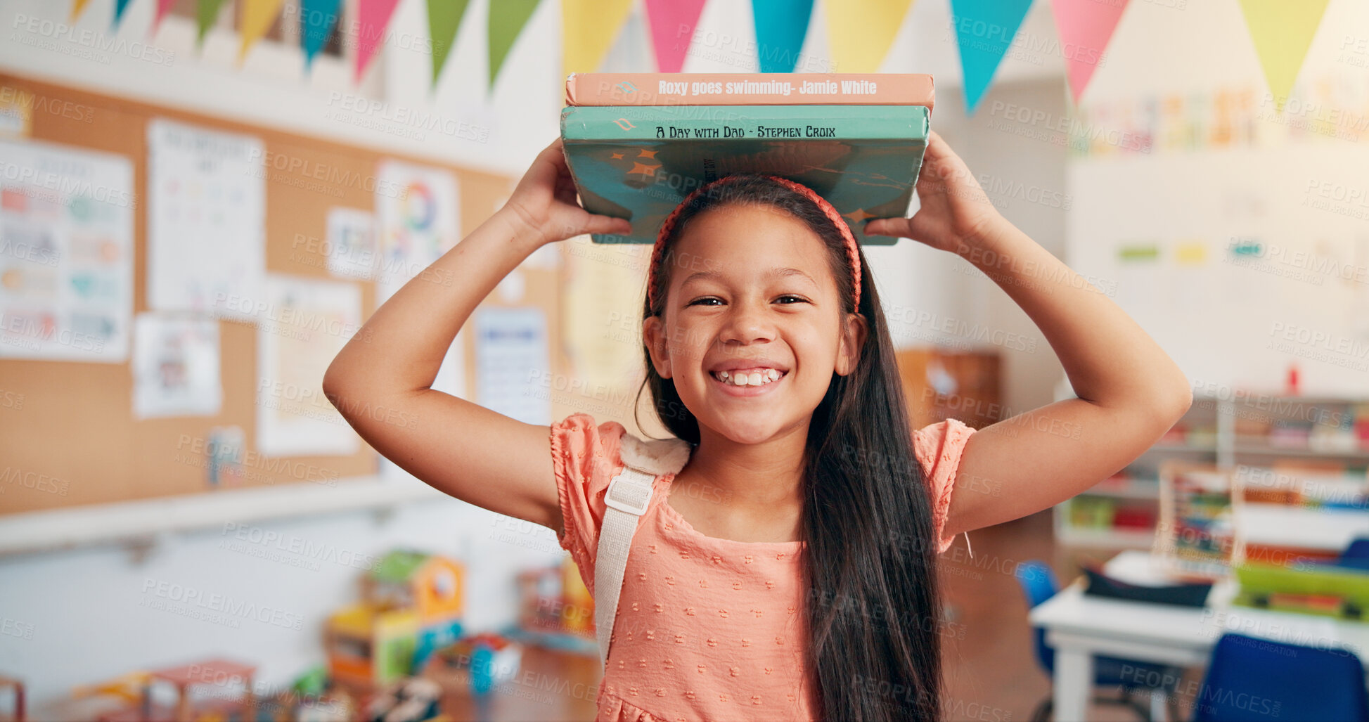 Buy stock photo Girl, smile and books on head at school, portrait and excited for education, story or development. Child, happy and learning in classroom, study and scholarship with reading at academy in Colombia