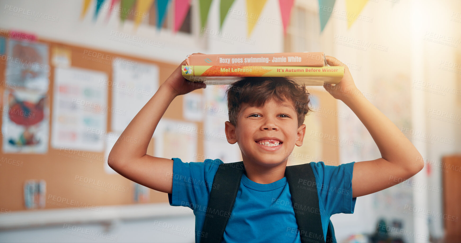 Buy stock photo Boy, portrait and books on head in classroom, smile and excited for education, story or development. Child, happy and learning at academy, start and scholarship with reading at school in Mexico