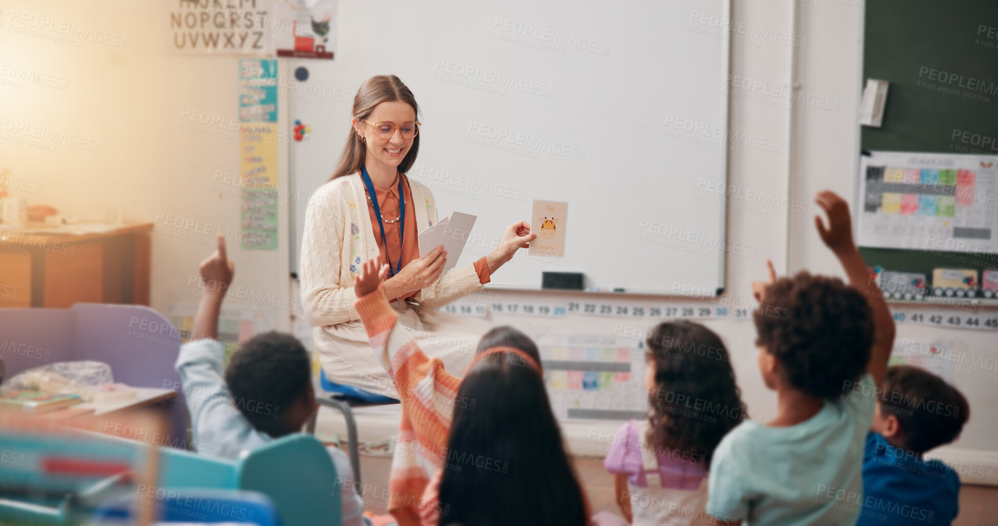 Buy stock photo Teacher, children and flash cards with answer in lesson for animal questions, alphabet knowledge or feedback. Educator, people and students with hands raised for creative development or language quiz