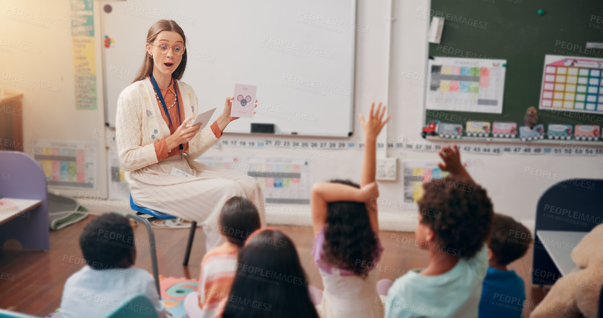 Buy stock photo Teacher, children and flash cards with lesson in classroom for animal alphabet, knowledge or question. Educator, people or students with hands raised for creative development, language quiz or answer