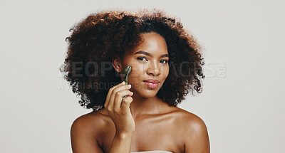 Buy stock photo Portrait, skincare and woman with jade roller in studio for skin glow, lymphatic drainage or detox circulation. African model, cosmetics tool or massage face for dermatology on white background space