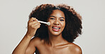 Portrait, cosmetics and woman with brush, makeup or model with tools for beauty, studio or confident. White background, glow and application of foundation with product,  African person or dermatology