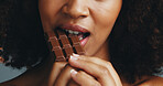 Studio, bite and person with chocolate, closeup and hands with delicious snack, dessert and eating. Mouth, taste and food with serotonin for woman, sugar or candy with health benefits of antioxidants