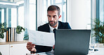 Businessman, documents and laptop with statistics for corporate finance, performance or budget at office. Man, accountant or analyst with paperwork, graph or chart for financial report at workplace