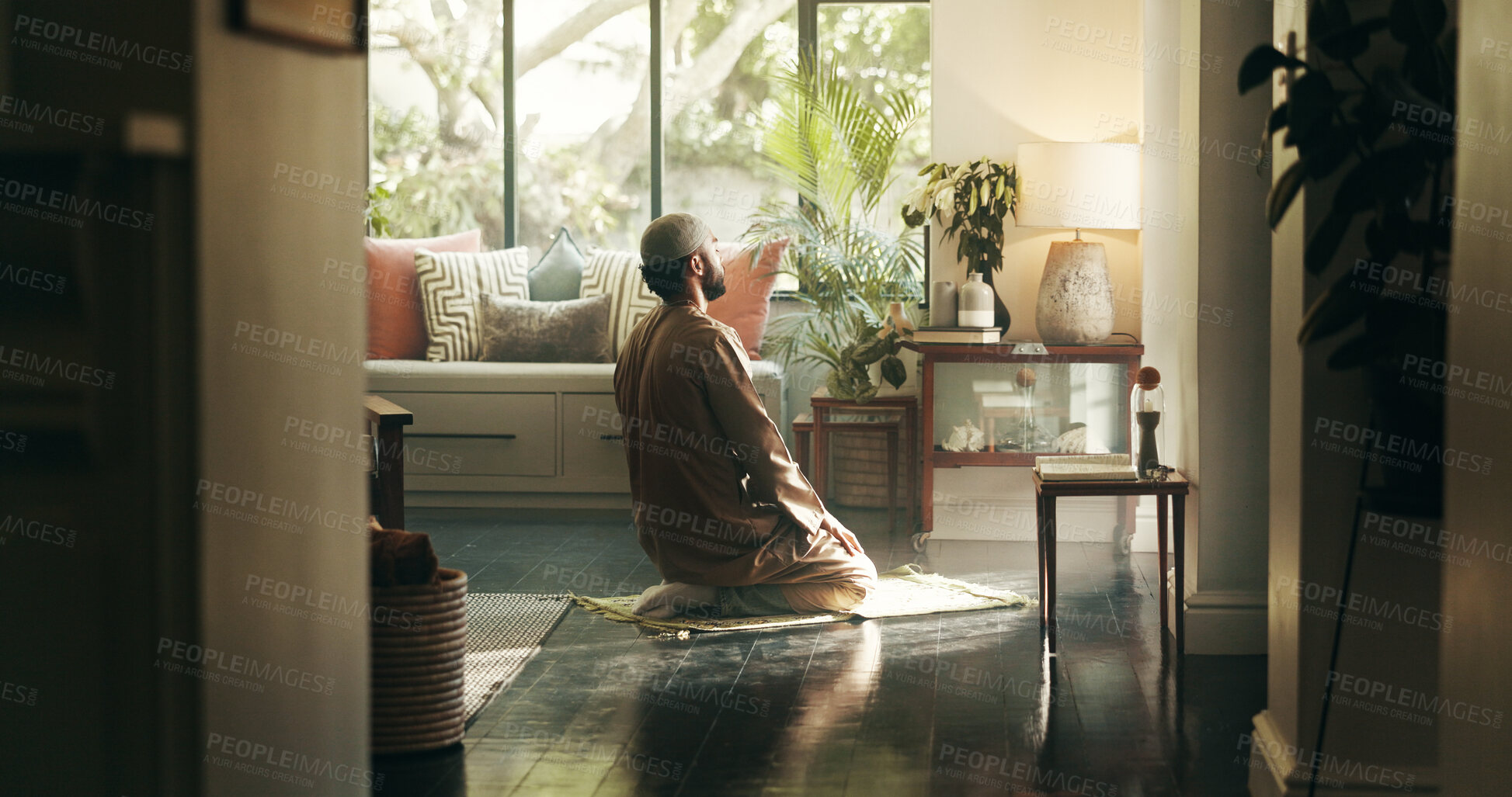 Buy stock photo Islam, man and kneeling in prayer in home for spiritual worship, praise Allah and belief in Ramadhan. Male person, salah and dua for reflection, mindfulness and fasting tradition of muslim religion