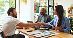 Handshake, colleagues and people with documents, cafe and happy with marketing proposal for campaign. Agreement, smile and planning with paperwork in coffee shop, brand manager or report for business