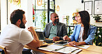 Collaboration, colleagues and people with documents, cafe or team with marketing proposal for campaign. Planning, smile and meeting with paperwork in coffee shop, brand manager or report for business