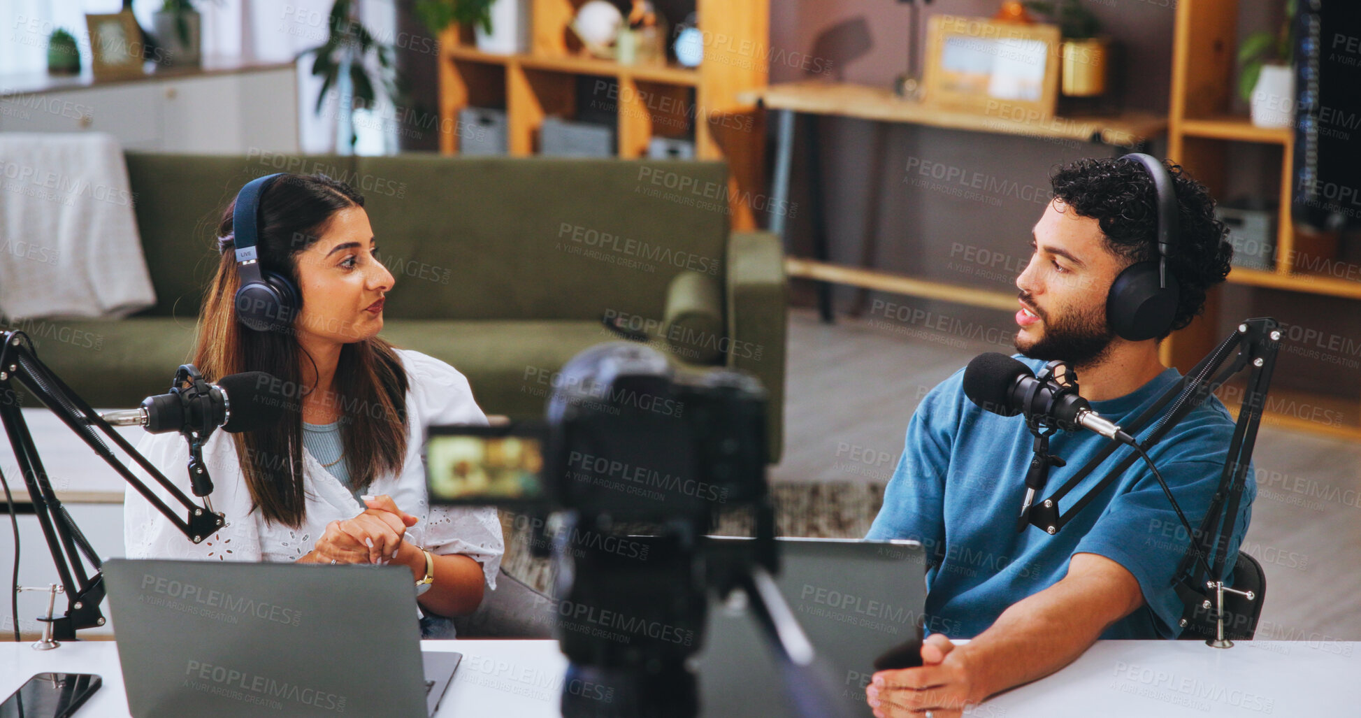 Buy stock photo Laptop, microphone and streaming with people in home living room for live broadcast or recording. Camera, conversation or podcast with man and woman influencer in apartment for subscription service