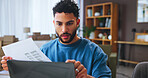 Small business, review and man with documents, laptop and confused by financial report and online. Reading, entrepreneur and person with paperwork for taxes, boxes and planning for audit or serious