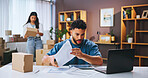 Small business, stress and man with documents, laptop and confused by financial report and online. Reading, people and entrepreneur with paperwork for taxes, boxes and planning for audit or serious
