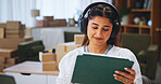 Woman, headphones and tablet for distribution startup with boxes, technology and internet for podcast. Home, checklist and shipping information for online order, logistics and small business tips