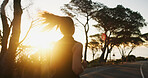 Woman, fitness and running with sunset on mountain road for workout, exercise or cardio training. Back view, female person or runner with sunshine on street for sprint, race or challenge in nature