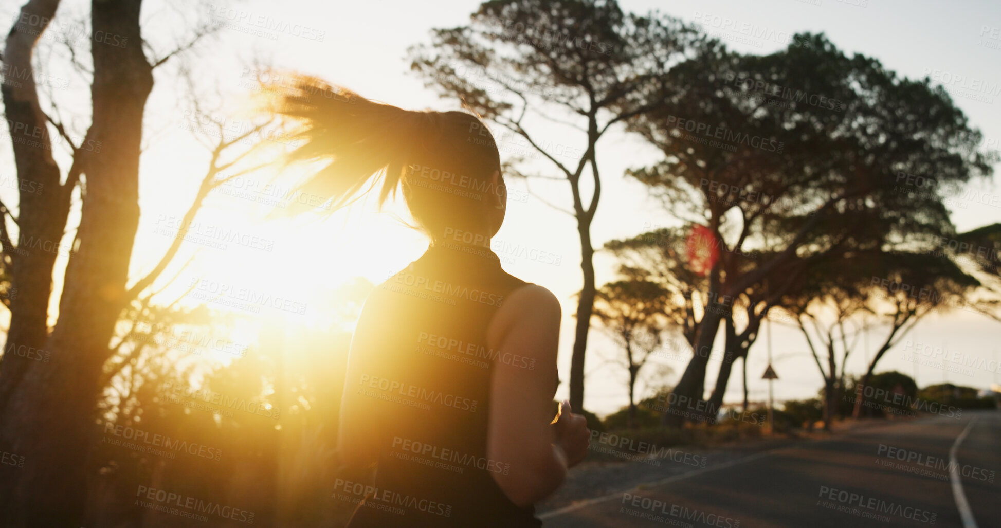 Buy stock photo Woman, fitness and running with sunset on mountain road for workout, exercise or cardio training. Back view, female person or runner with sunshine on street for sprint, race or challenge in nature