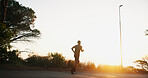 Man, fitness or running with sunset on mountain road for workout, exercise or cardio training. Back view, male person or runner with sunshine on asphalt street for sprint, race or challenge in nature