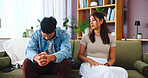 Disappointed, conflict and couple in home, thinking and betrayal for man in relationship, hurt and lounge. Contemplating, pain and woman with regret for cheating, divorce and heartbreak for people