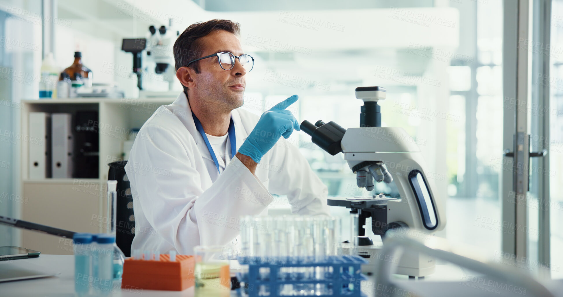 Buy stock photo Scientist, man and thinking by microscope in lab for medical research with container, review or vaccine development. Person, problem solving and chemical analysis with pharmaceutical trial for study