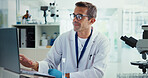 Scientist, man and typing with laptop in lab for medical research with results, smile and vaccine development. Person, happy and computer for test, notification and feedback for pharmaceutical trial