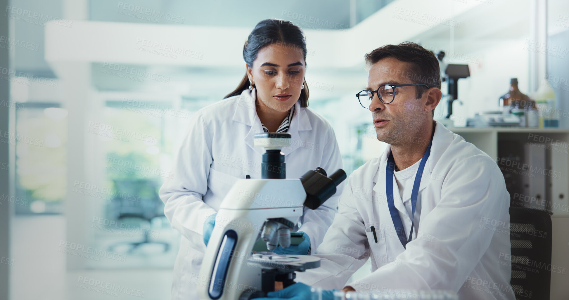 Buy stock photo Scientist, people and microscope in lab for advice, testing and medical research. Pathology, man and science assistant with mentor report for pharmaceutical or biotech experiment for breakthrough