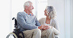 Senior couple, holding hands and wheelchair in home, smile or care with help for injury in retirement. People, woman and support for elderly person with disability, rehabilitation or love in house