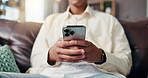 Phone, hands and man on sofa in home for social networking on mobile app for connection. Cellphone, communication and closeup of male person texting for online dating in living room at apartment.
