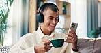 Sofa, man and coffee with mobile for music, wellness and comfortable at home in morning. House, happy person and relax with headphones for listening sound, espresso and smartphone app for audio track