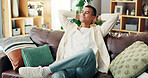 Home, couch and man with stretching for relax, comfortable and self care for mental health in living room. House, male person and smile on sofa for chilling, resting or happiness with peace in lounge