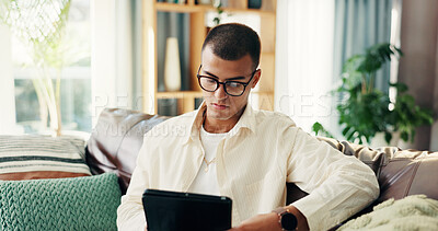 Buy stock photo Home, man and glasses with tablet on sofa, reading blog and subscription for newsletter in lounge. House, male person and relax with digital for ebook, social media post and connection in living room