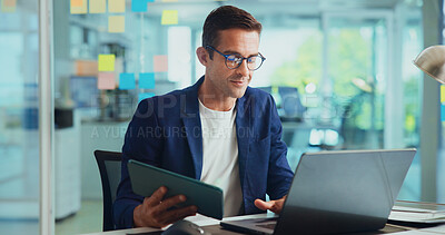 Buy stock photo Office, businessman and tablet with laptop for reading, typing article and research for news story. Career, male person and journalist from creative agency with digital, editing and website for blog