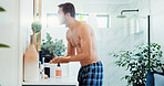 Beauty, lotion and mirror with man in bathroom of home for hygiene or morning routine. Profile, moisturiser and skincare with shirtless person in apartment for grooming, inspection or shaving