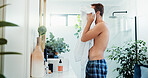 Man, shower and drying face with towel in bathroom for grooming or morning routine at home. Male person, fabric or skincare with equipment, cloth or prep for facial treatment or hygiene at house