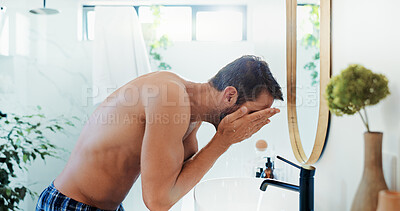 Buy stock photo Man, face wash and water with mirror in bathroom for skincare hygiene and cleaning at home. Topless person, rinse and facial treatment with hydration for morning routine, grooming or dermatology