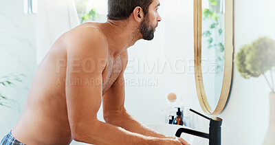 Buy stock photo Man, face and wash with mirror in bathroom for grooming or morning routine at home. Topless person, reflection or skincare with faucet or water for freshness, facial treatment or hygiene at house