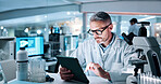 Tablet, man and scientist in laboratory for medical research, experiment or study for innovation. Reading, glasses and mature male chemist with digital technology for online pharmaceutical report.