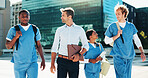 Professor, group and students walking in city for medical study, nursing program and healthcare opportunity. People, teacher and travel with morning commute, learning internship and university course