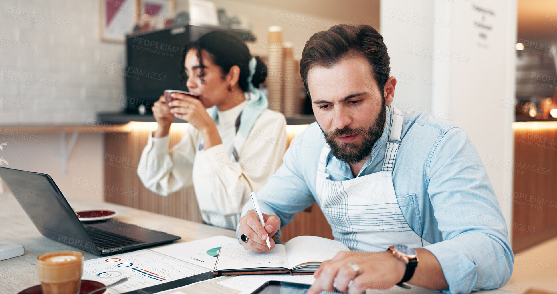Buy stock photo Businessman, tablet and notebook in cafe for review, social media and retail management notes. Owner, manager and laptop in coffee shop for sales report, restaurant profit or hospitality startup