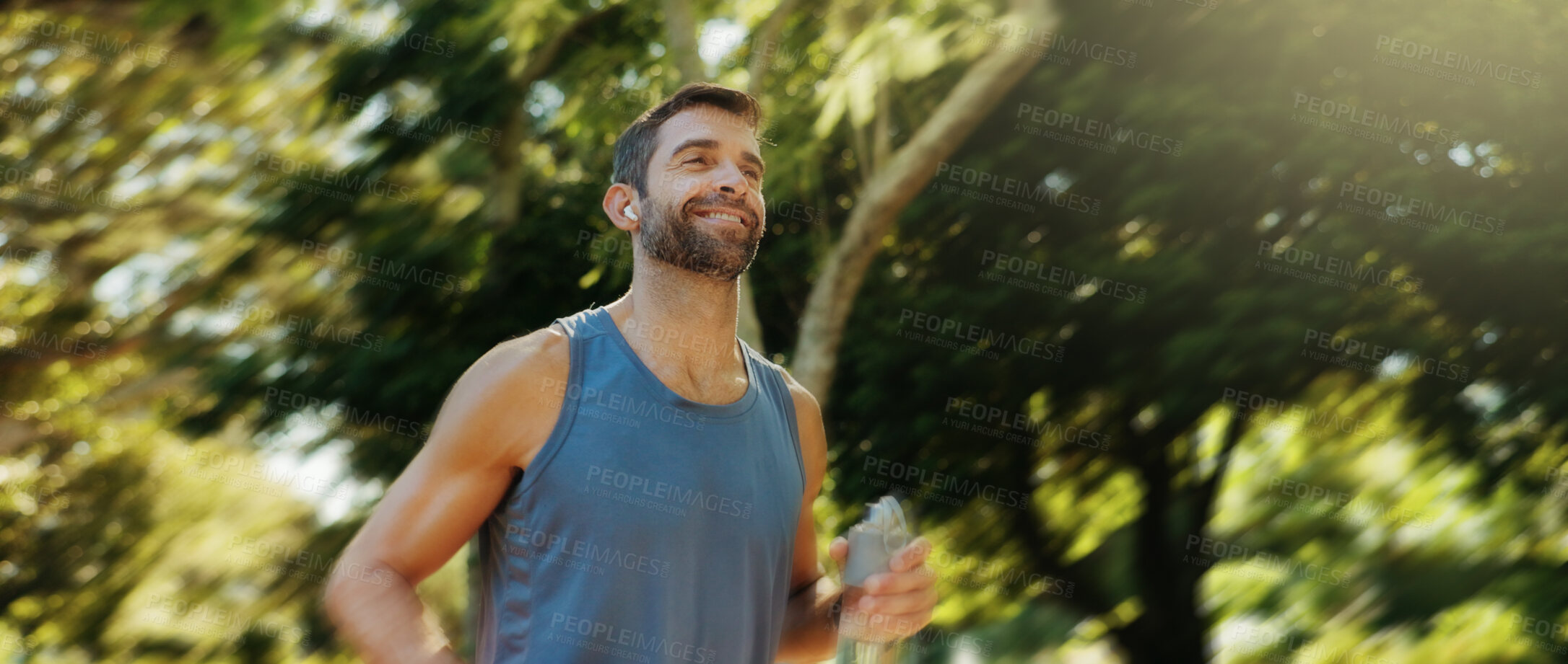 Buy stock photo Smile, active man and earpods for running outdoor of cardio exercise, endurance training and marathon practice. Male athlete, runner and sports workout, fitness performance and listening to podcast