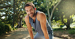 Portrait, active man and rest outdoor for running exercise, training recovery and practice for marathon. Tired, male person and relax for sports workout, fitness performance and listening to podcast