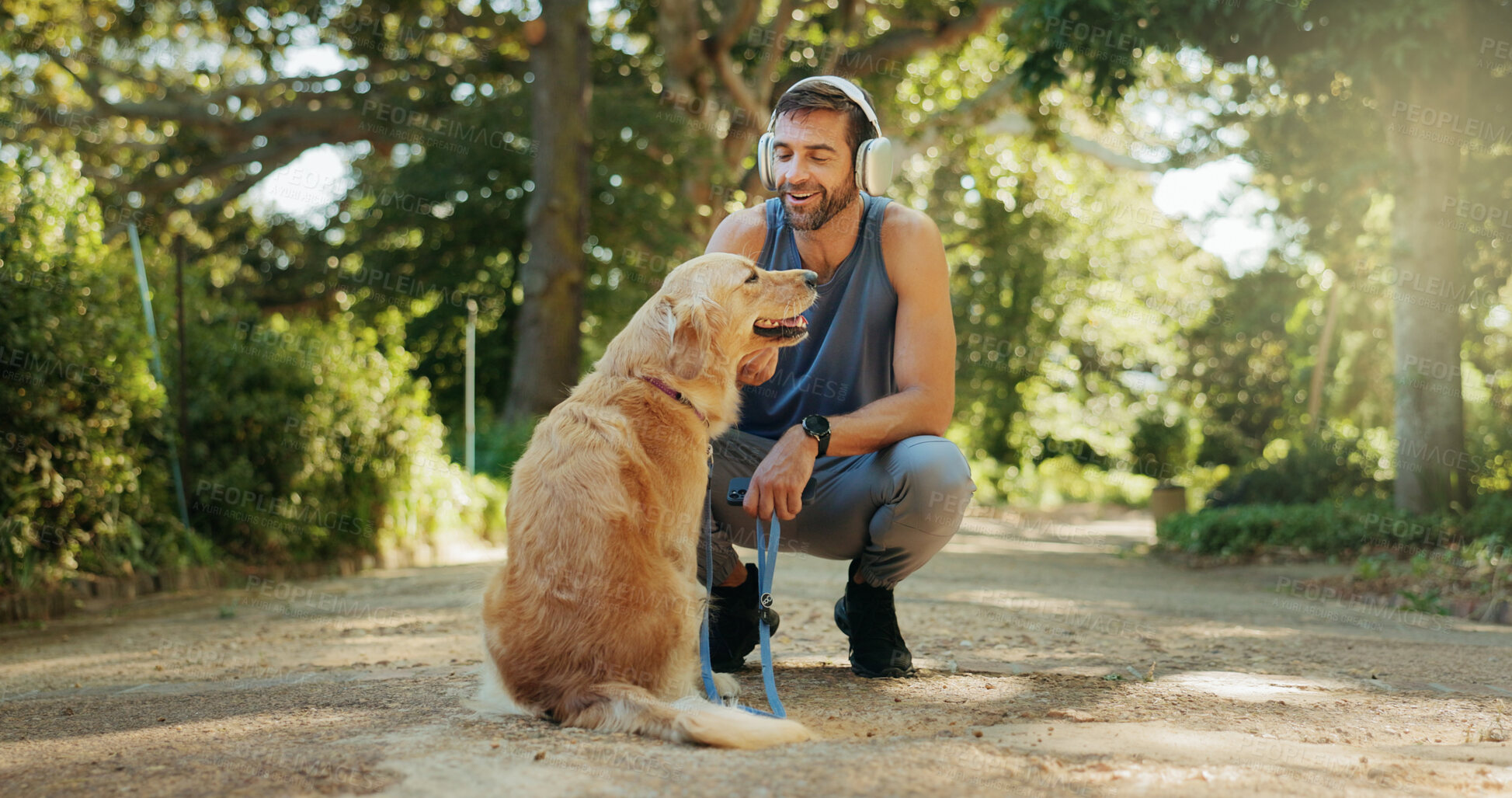 Buy stock photo Outdoor, dog and man with exercise, headphones and playful with nature, wellness and fitness. Best friend, animal and pet with athlete, runner and listening to music, training and workout in park