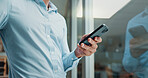 Hands, phone and texting by window in office with reflection, contact and notification on web at startup. Business person, chat or click on mobile app, social media or networking at creative agency