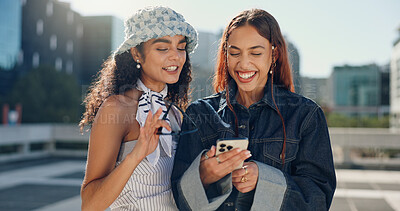 Buy stock photo Women, friends and laughing with phone in city for social media, reading funny blog and bonding reunion. Happy, people and streetwear fashion on mobile, gossip news and streaming video for urban trip