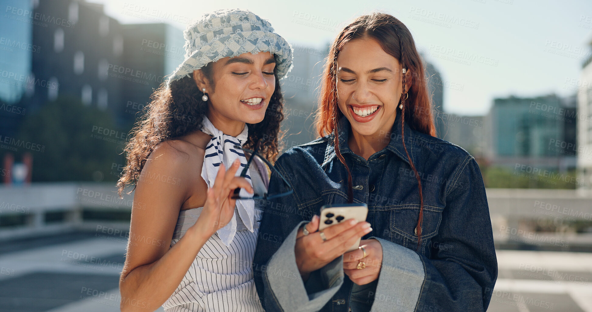 Buy stock photo Women, friends and laughing with phone in city for social media, reading funny blog and bonding reunion. Happy, people and streetwear fashion on mobile, gossip news and streaming video for urban trip