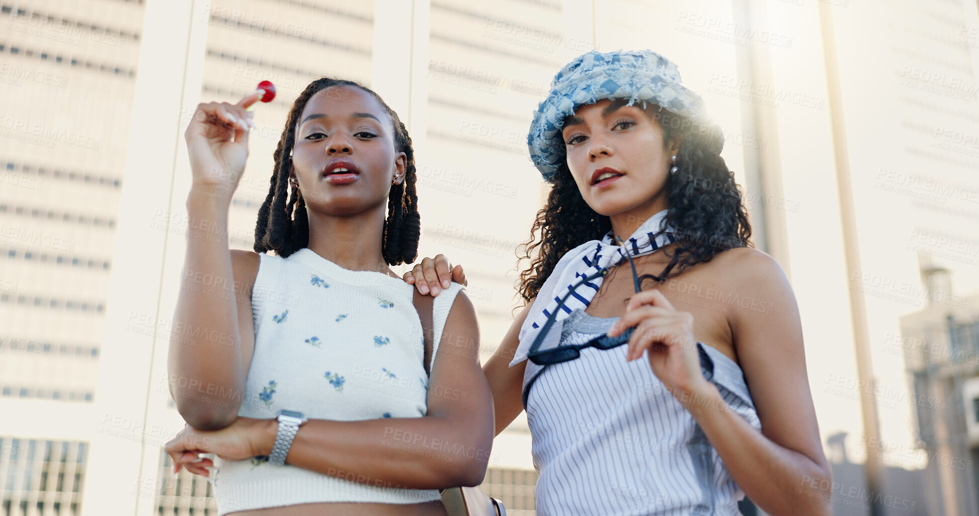 Buy stock photo Streetwear, cool and women in city with fashion or lollipop for urban, edgy and trendy style together. Low angle, gen z friends and creative people in town for youth culture, unique outfit and swag