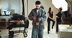 Camera, photography and review with man in studio for checking results of photoshoot production. Backstage, getting ready or media with makeup artist, model and photographer on set for filming