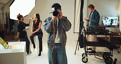 Buy stock photo BTS, camera and shooting with photographer man in studio catalog or magazine photoshoot. Creative, focus or media with makeup artist and model getting ready on set in preparation of photography