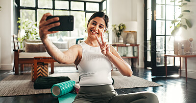 Buy stock photo Peace sign, selfie and yoga with woman in living room of home for health, pilates or wellness routine. Exercise, holistic and social media with Indian person on floor of apartment for mindful balance