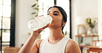 Break, drinking water and fitness with woman in home for exercise, hydration or wellness workout. Bottle, relax and training with thirsty person in living room of apartment for health or pilates