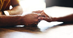 Closeup, couple and holding hands with trust for support, respect and bonding together with care in marriage. Restaurant, man and woman with compassion for hope, connection and commitment with love